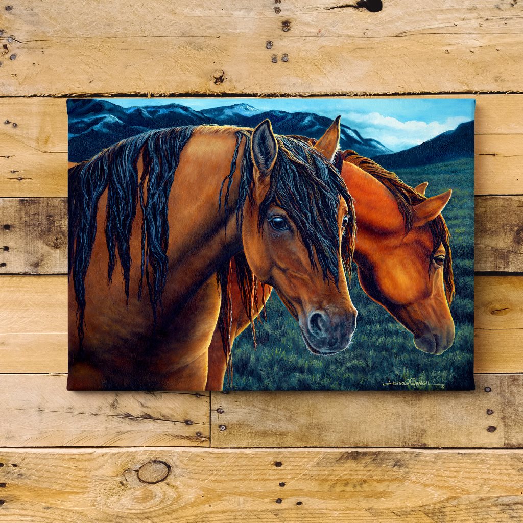 Kiger Mustangs Art Print - Golden Hour depicts two wild horses, a chestnut mare and bay stallion, standing close together at sunset. Their detailed faces and flowing manes are illuminated by warm evening light, set against a backdrop of mountains and green pasture, capturing the majestic beauty of wild mustangs.