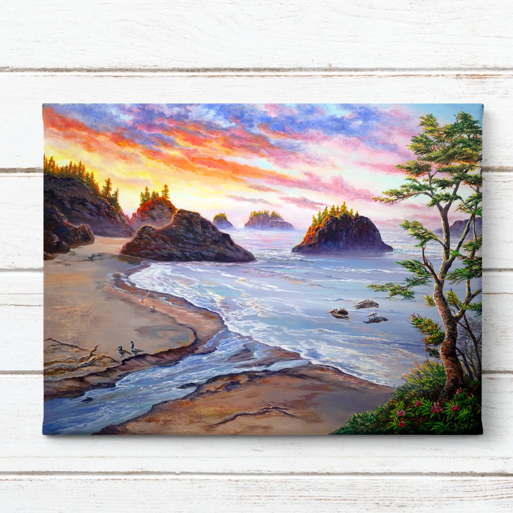 Secret Beach Oregon Coast Sunset Art Print captures a serene coastal landscape with dramatic rocky outcrops, gentle waves meeting sandy shores, and vibrant sunset colors painting the sky in orange, pink and purple hues. Pine trees frame the scene while offshore sea stacks emerge from tranquil waters. By Jeanne Warren